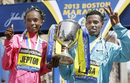 Rita Jeptoo of Kenya and Lelisa Desisa of Ethiopia pose with a trophy at the finish line after winning the women's and men's divisions of the 2013 Boston Marathon in Boston Monday, April 15, 2013. (photo: AP) 