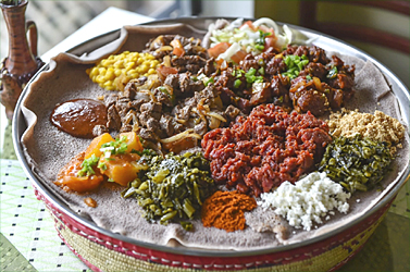 Lamb tibs, center left, gored gored, center right, and kitfo, center bottom, surrounded by sides of cottage cheese, collard greens, split peas, potatoes, carrots and salad at Bete Ethiopian Cuisine and Cafe. (Ricky Carioti/The Washington Post)