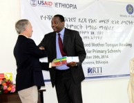 Mr. Dennis Weller, USAID Ethiopia Mission Director, handed over a sample of the new reading curriculum textbooks to Ato Shiferaw Shigute, Minister of Education, at the READ Launching Ceremony. Photo Credit : USAID/READ TA